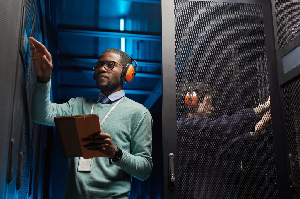 IT professionals working together among server racks in a data center