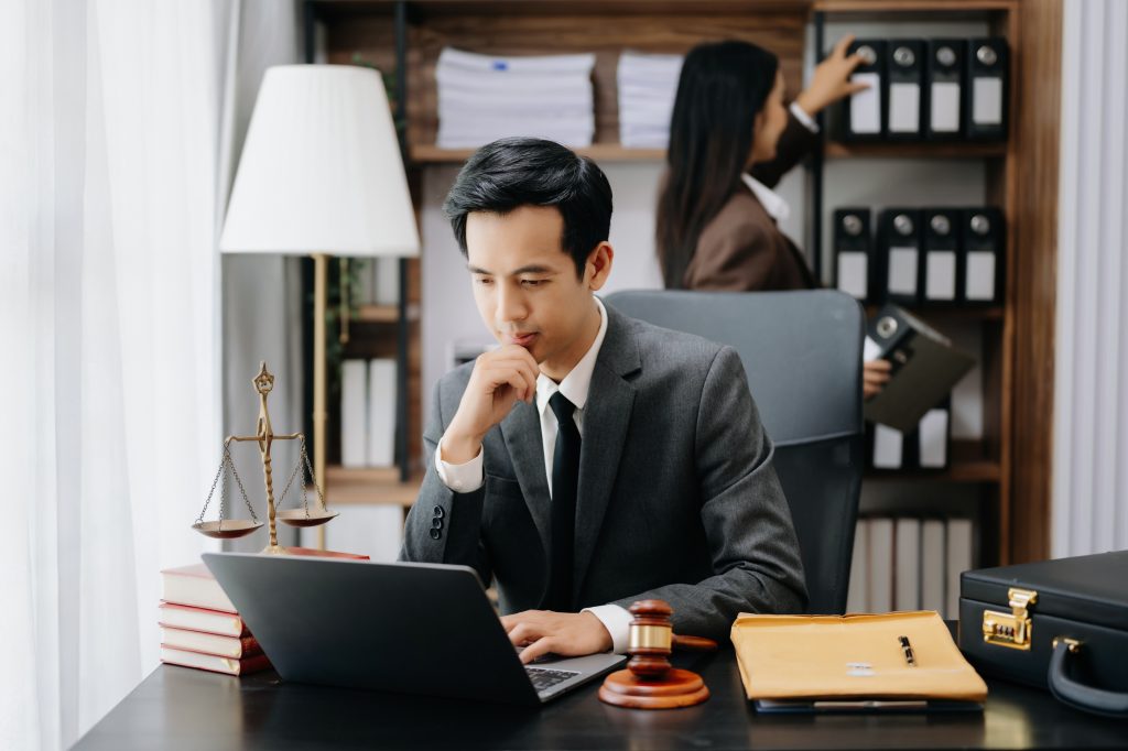 Attorney working at a desk with an assistant beside them